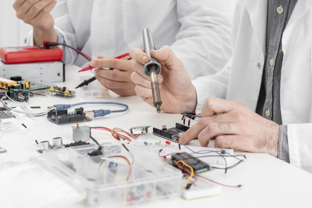 Close-up image of men in a lab conducting experiments, focusing on technical equipment and hands-on work.