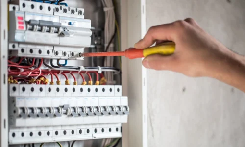 Licensed electrician upgrading a switchboard to improve energy efficiency on the Gold Coast